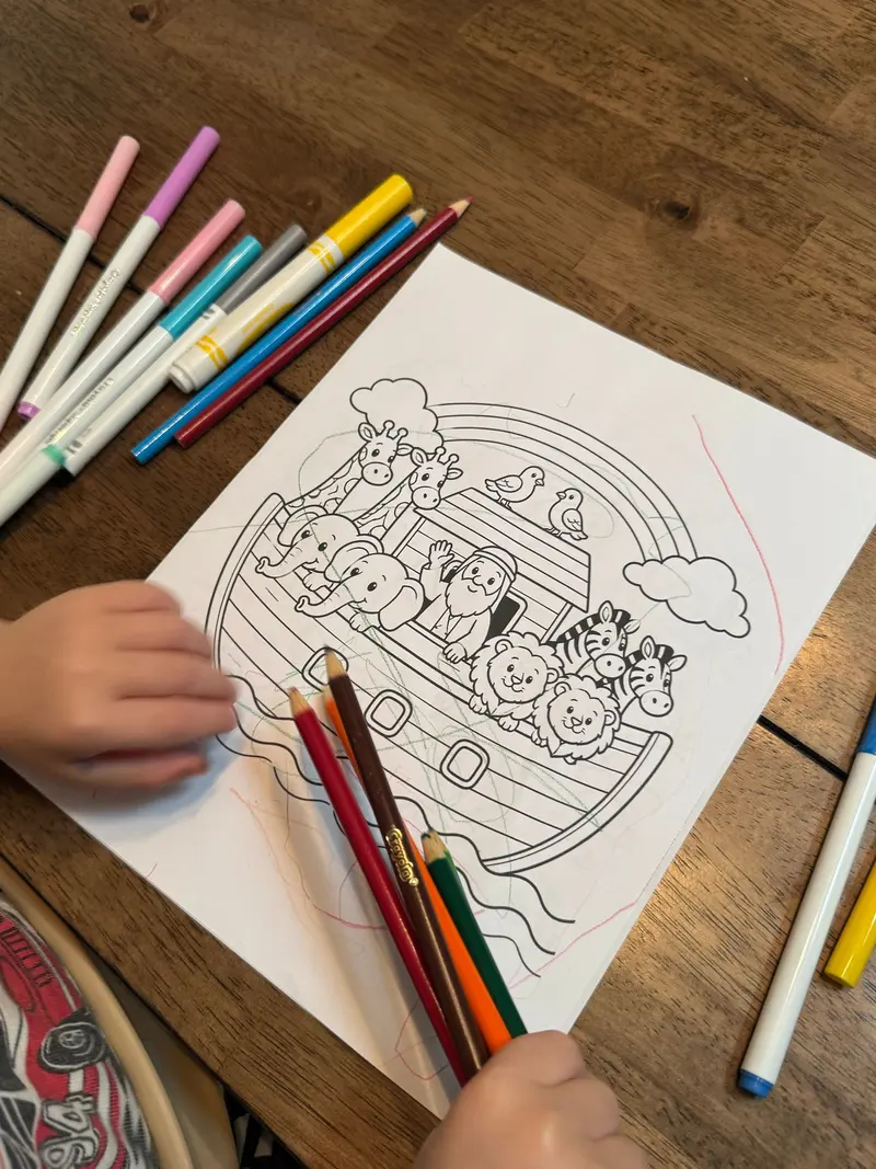 A child coloring the Noah's Ark coloring page