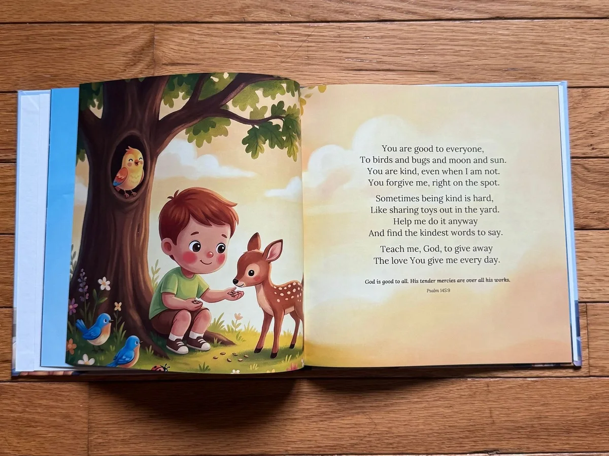 A hardcover copy of Little Prayers open on a wood floor at the kindness prayer, with a boy feeding a fawn under a tree.